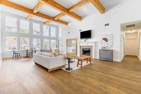 a living room with a white couch and a fireplace    and large windows